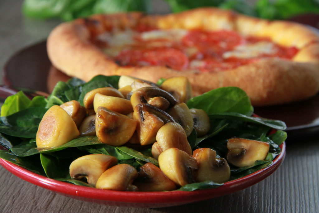 Pizza mit Mozzarella und Tomate  mit einem Salat aus Blattspinat und Champignons